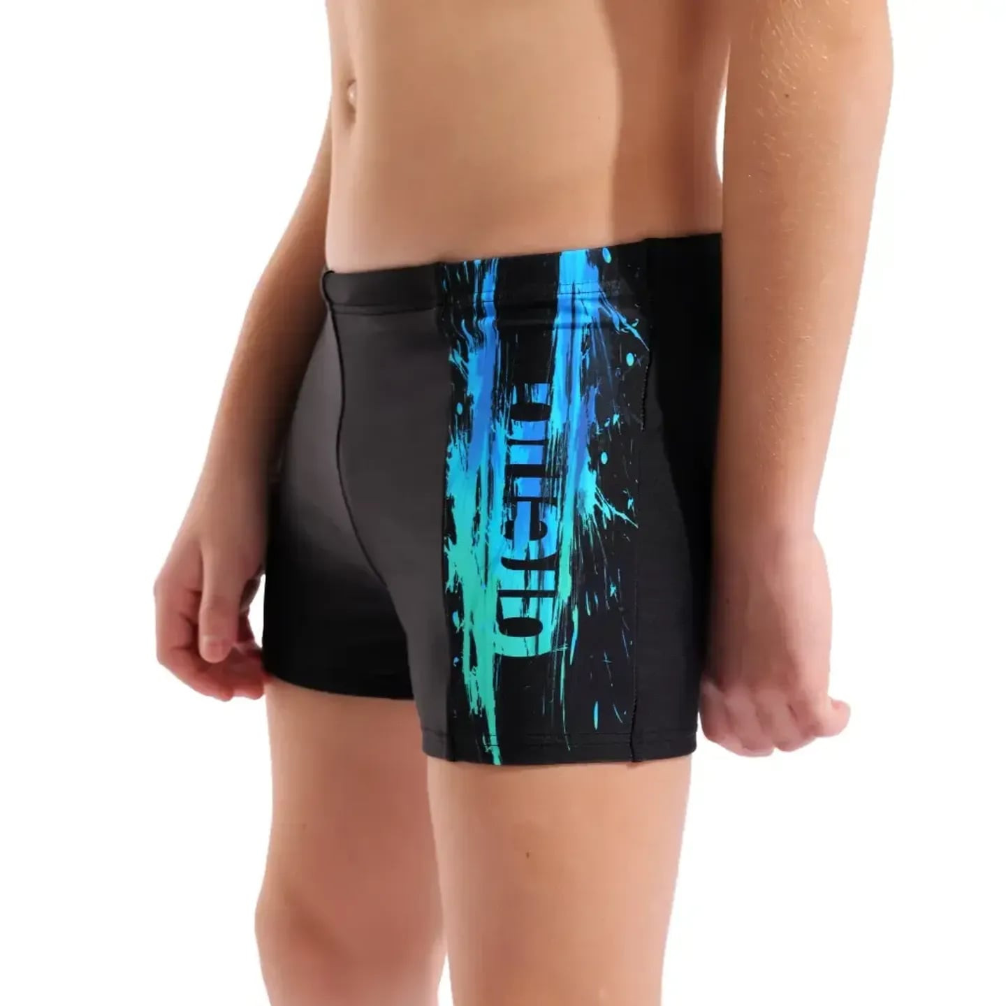 Jeune garçon en short de bain Arena Paint Maxfit Eco, prêt à nager dans une piscine lumineuse