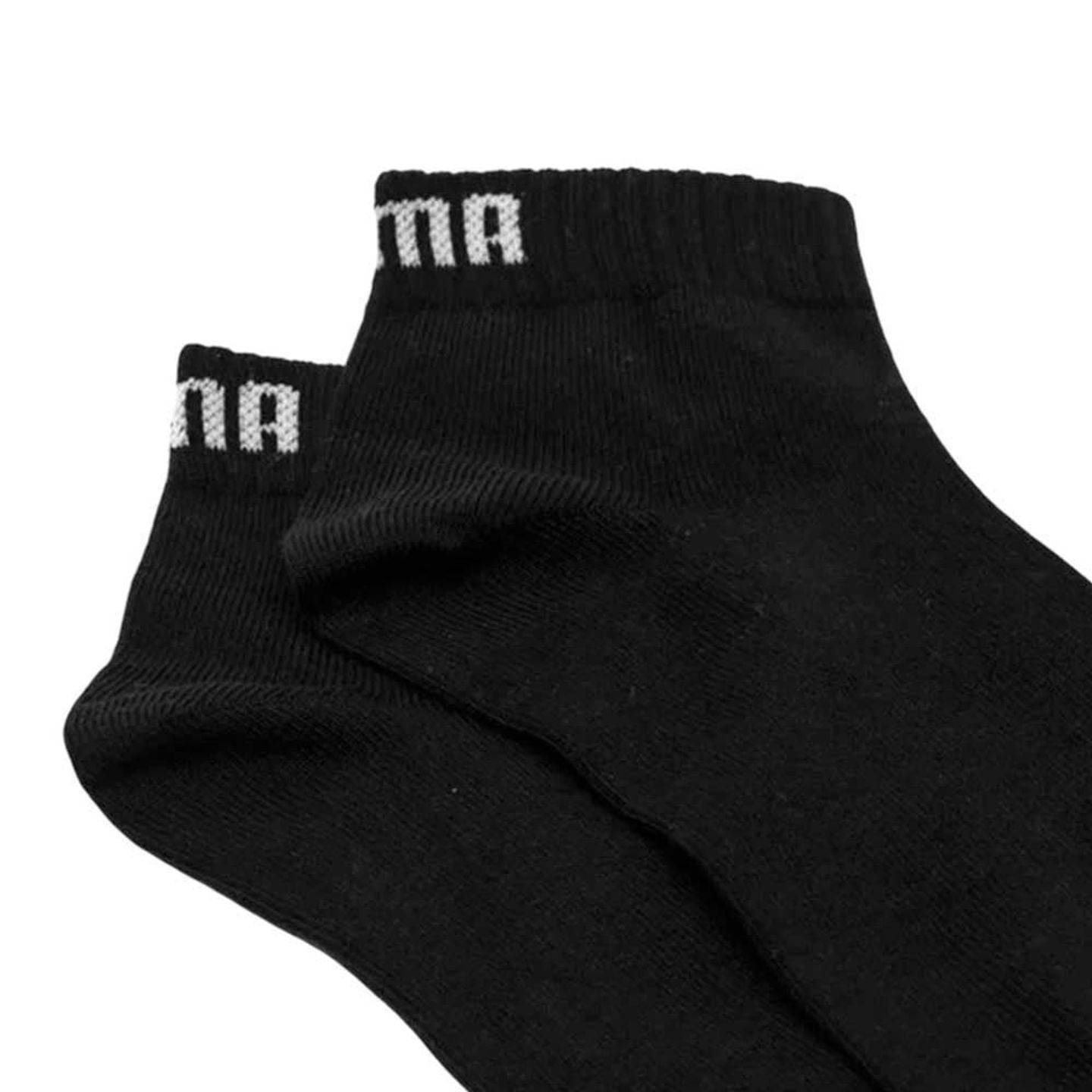 Gros plan sur les bords côtelés élastiques des chaussettes PUMA Kids Plain Quarter noires, avec lett