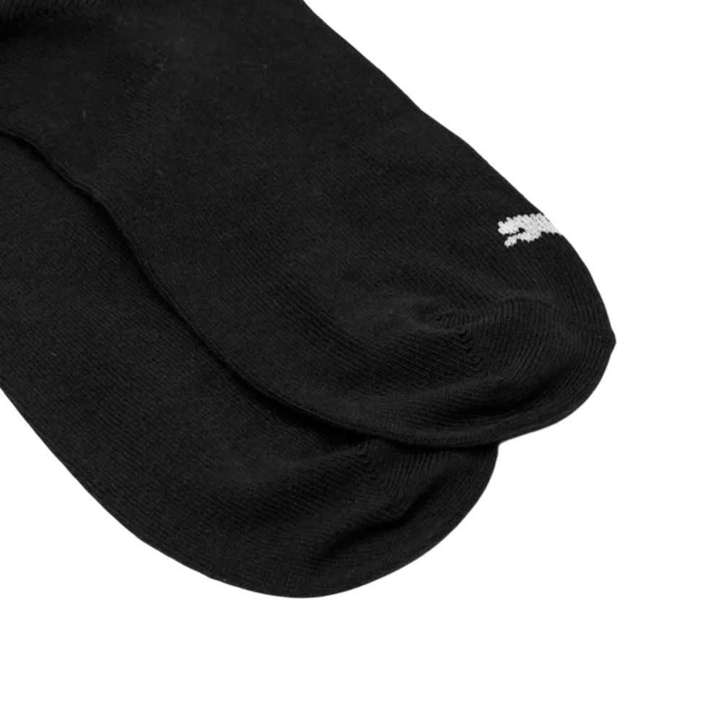 Gros plan sur le bout d'une chaussette PUMA Kids Plain Quarter noire, avec logo chat blanc PUMA et c