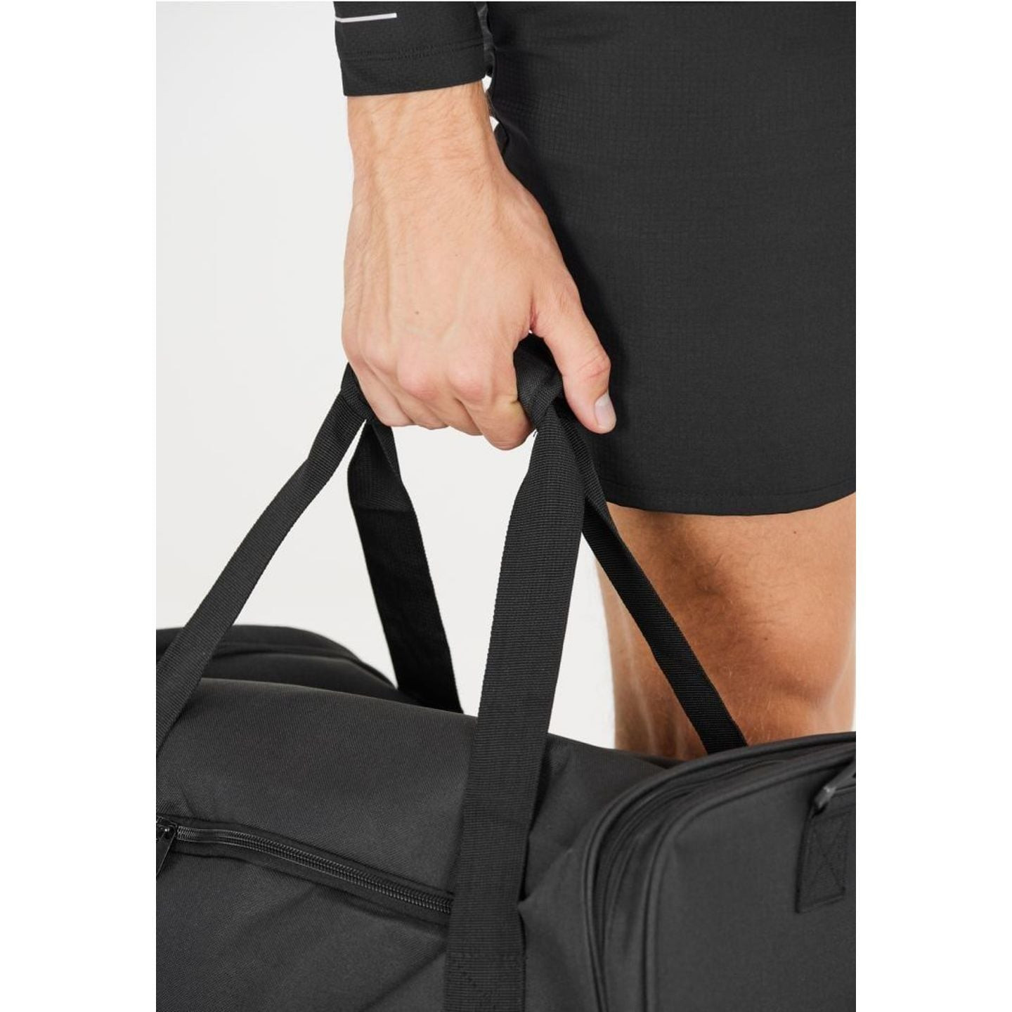 Athlète tenant les poignées courtes rembourrées du sac de sport noir Endurance Lanakila 40 L