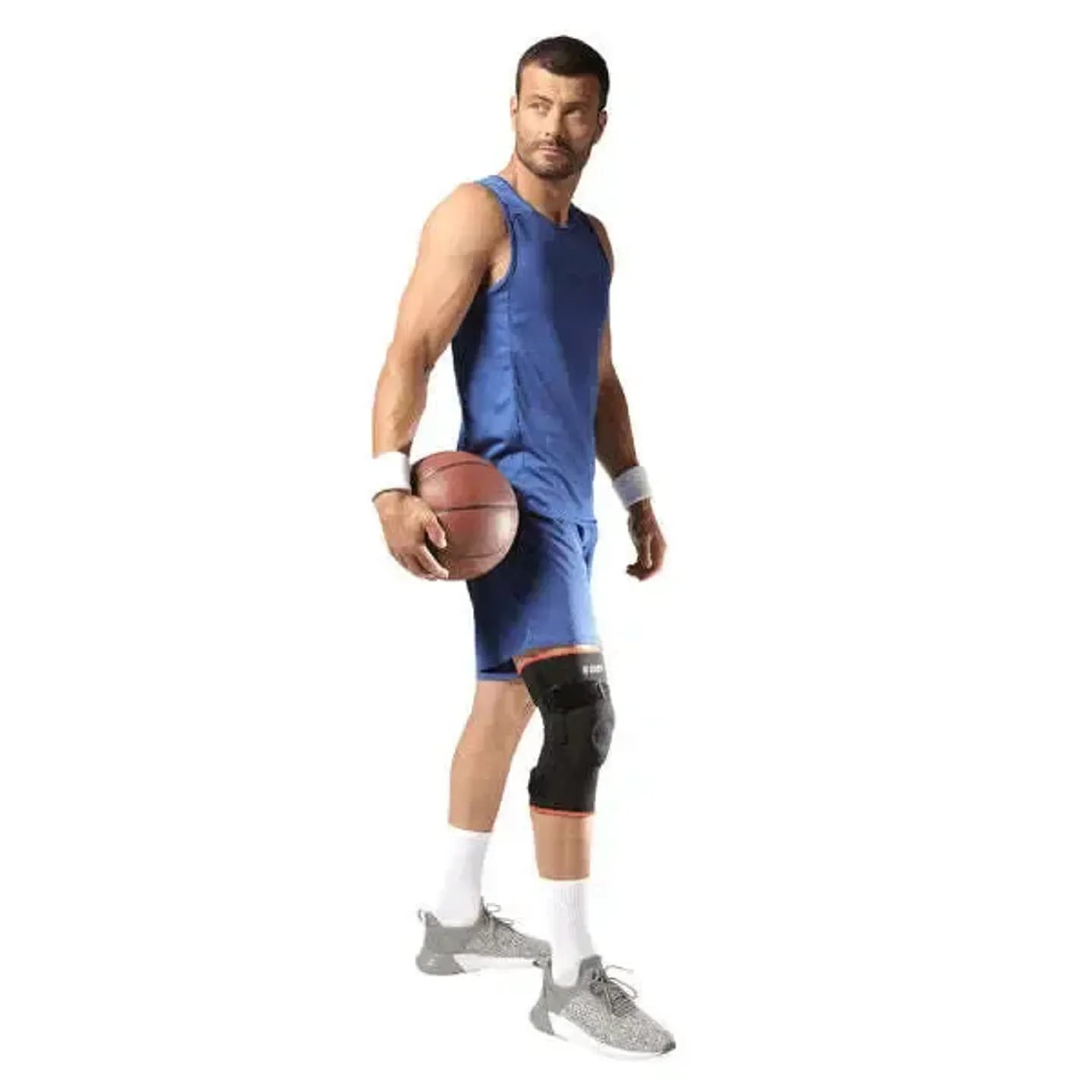 Joueur de basket en tenue bleue, ballon à la main, portant une genouillère noire Thuasne Sport