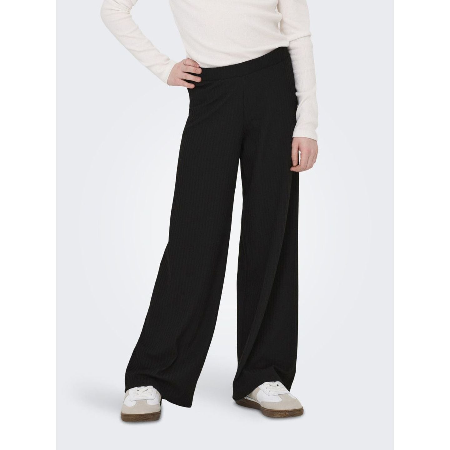 Vue rapprochée d'une fille portant le pantalon jambe large KOGNELLA PANT JRS NOOS noir avec baskets 