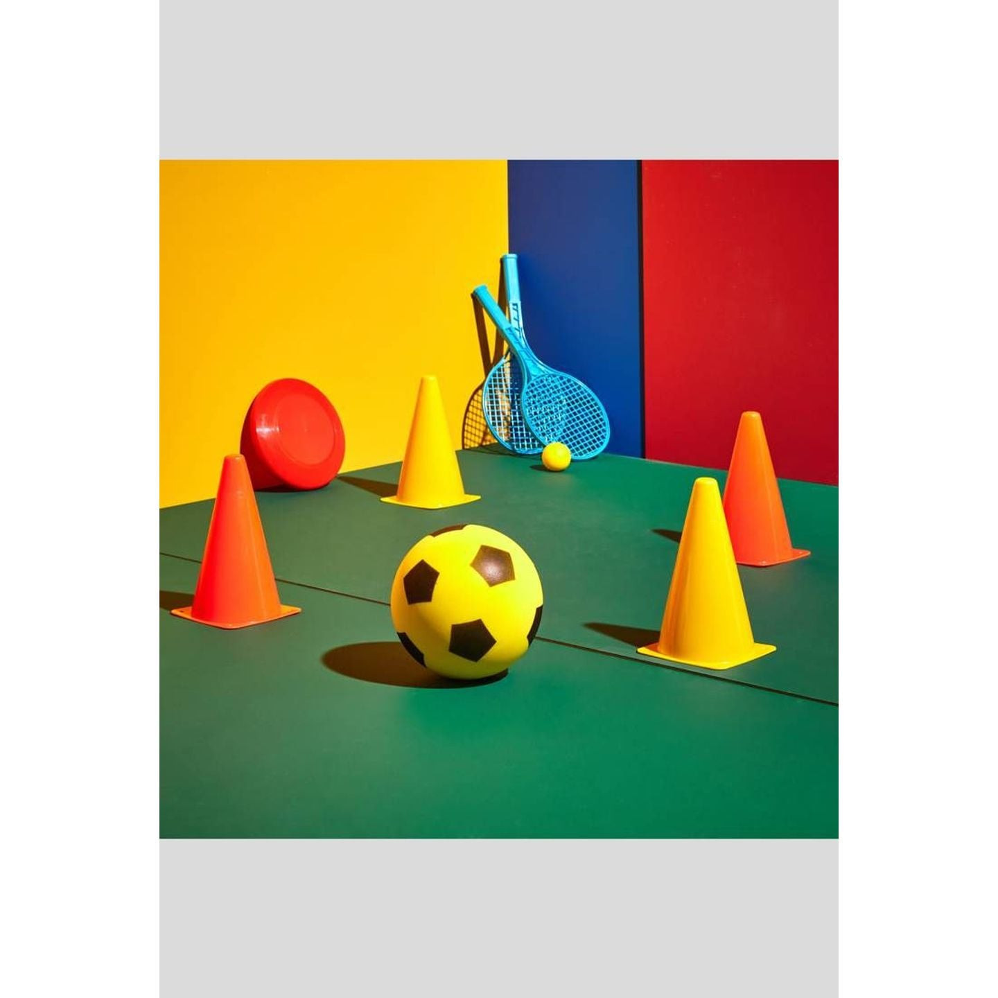 Scène de terrain de jeu colorée avec raquettes de tennis, frisbee, ballon en mousse et cônes d'entra