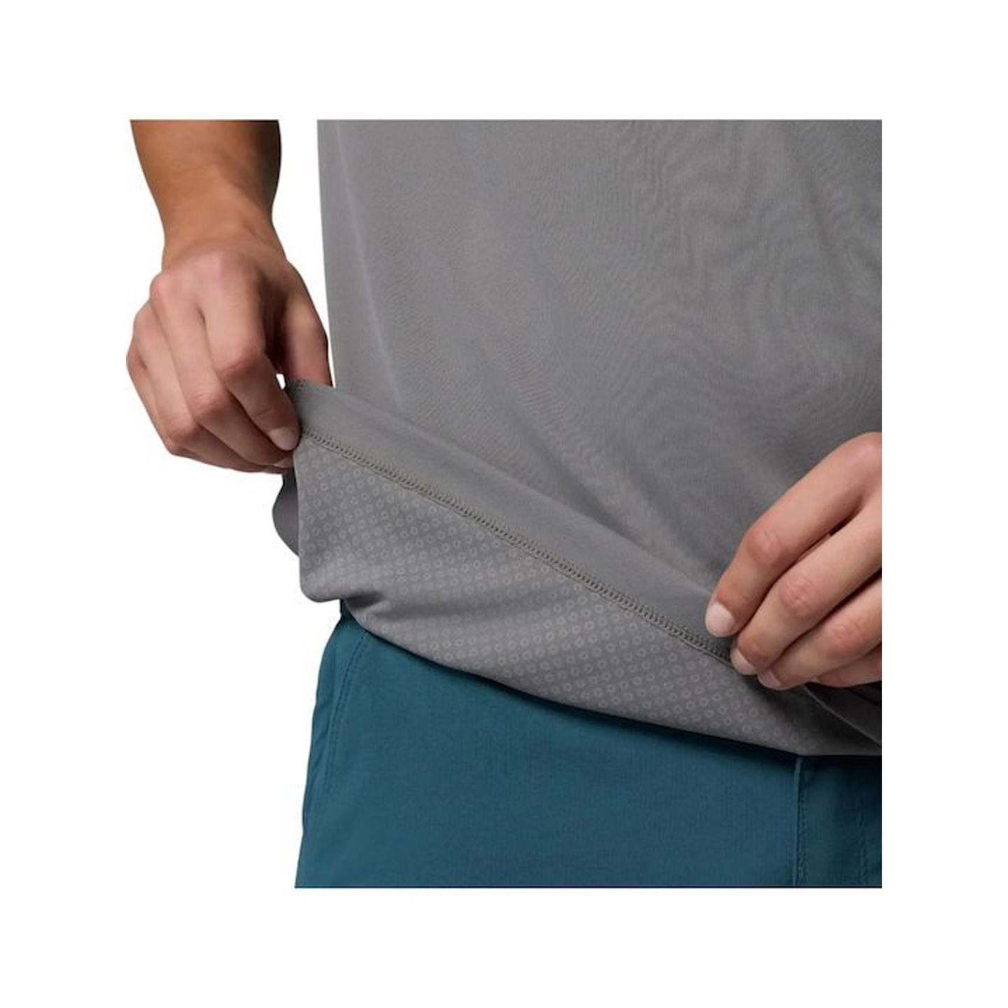 Gros plan sur des mains étirant l'ourlet d'un t-shirt Columbia gris, montrant la texture du tissu et
