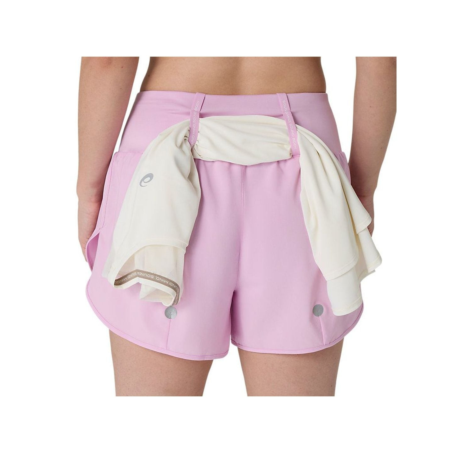 Gros plan sur un short ASICS ROAD 3.5IN rose avec une veste blanche glissée dans les boucles élastiq
