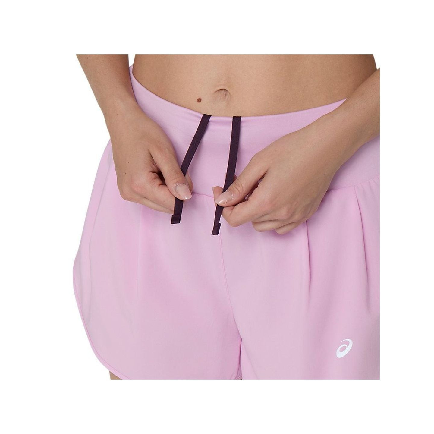 Gros plan sur les mains serrant le cordon de la large ceinture rose du short ASICS ROAD 3.5IN pour f
