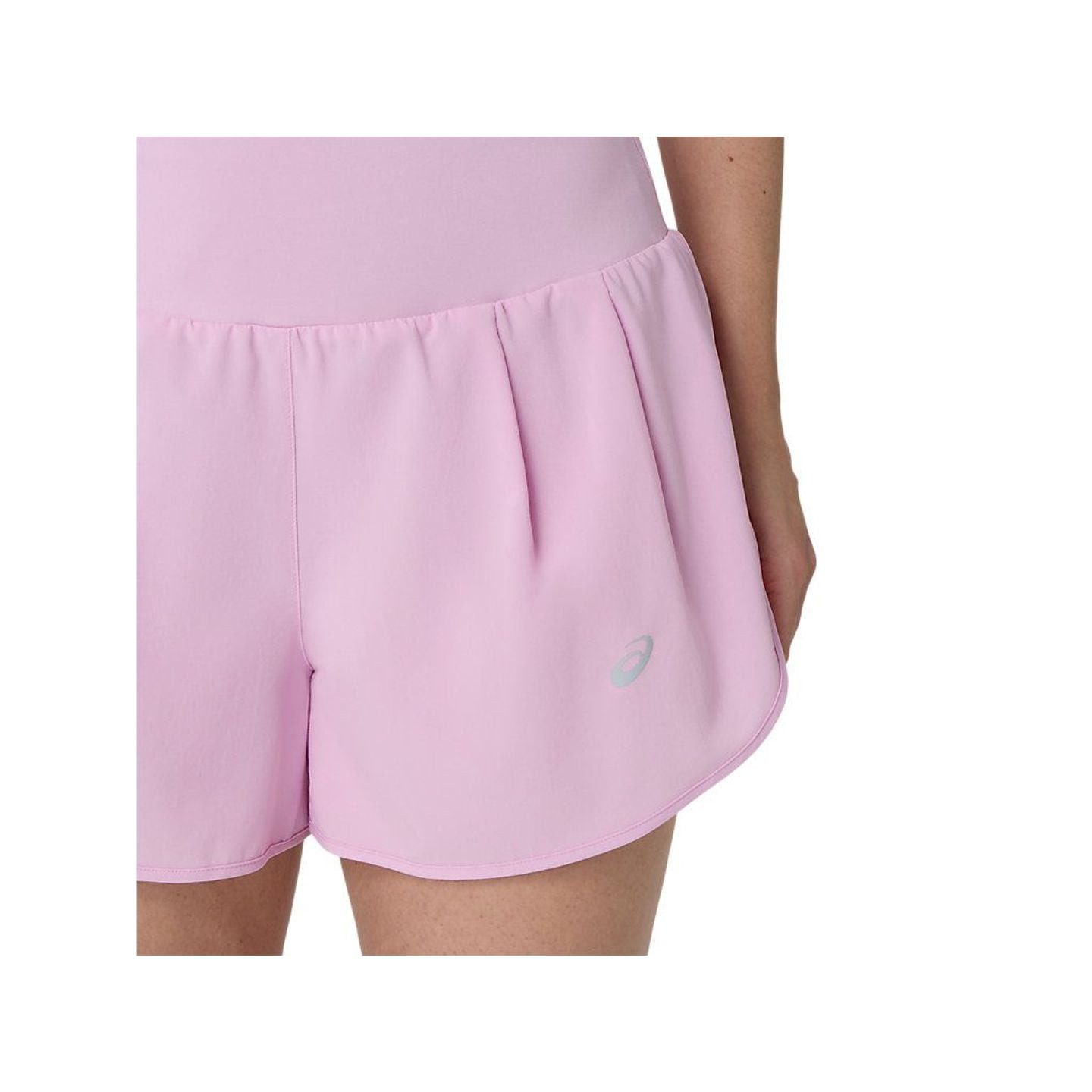 Gros plan sur l'ourlet incurvé et le logo ASICS réfléchissant sur le côté du short rose ROAD 3.5IN