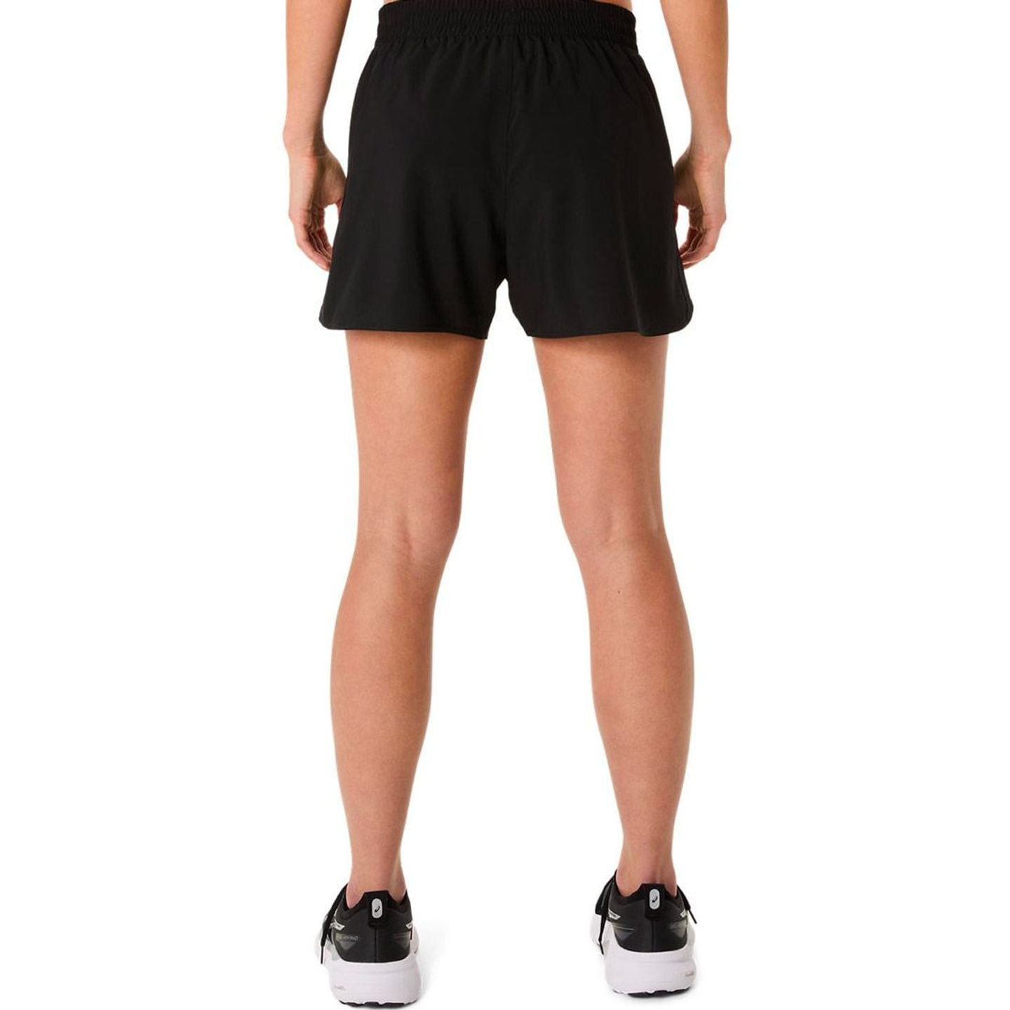 Coureuse portant le short ASICS Core 4In Femme léger et respirant pendant une course estivale