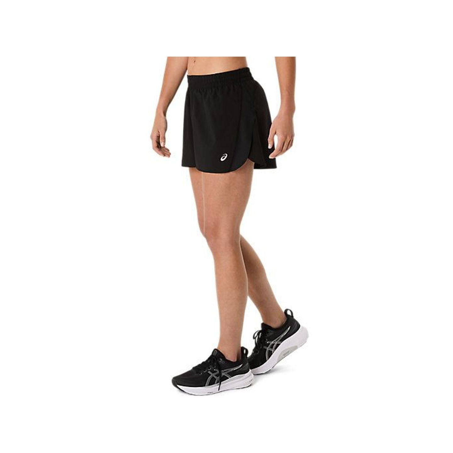 Mannequin marchant dans le short ASICS Core Split noir, vue de côté montrant la fente latérale et la
