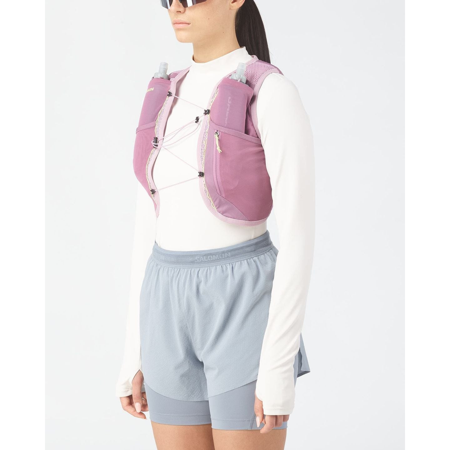 Coureuse portant le Salomon Gilet D'Hydratation Trail Active Skin 4 SensiFit Femme sur un sentier