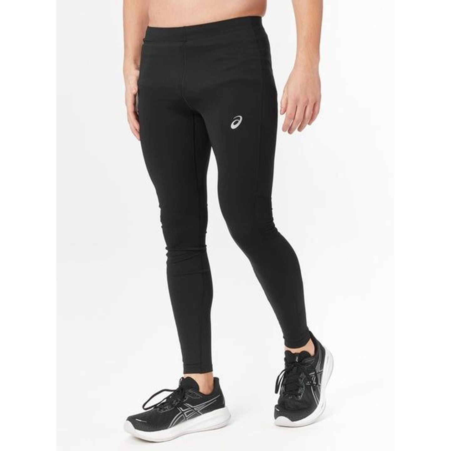 Vue de profil d'un coureur portant le collant ASICS Core Tight noir et des chaussures ASICS blanches