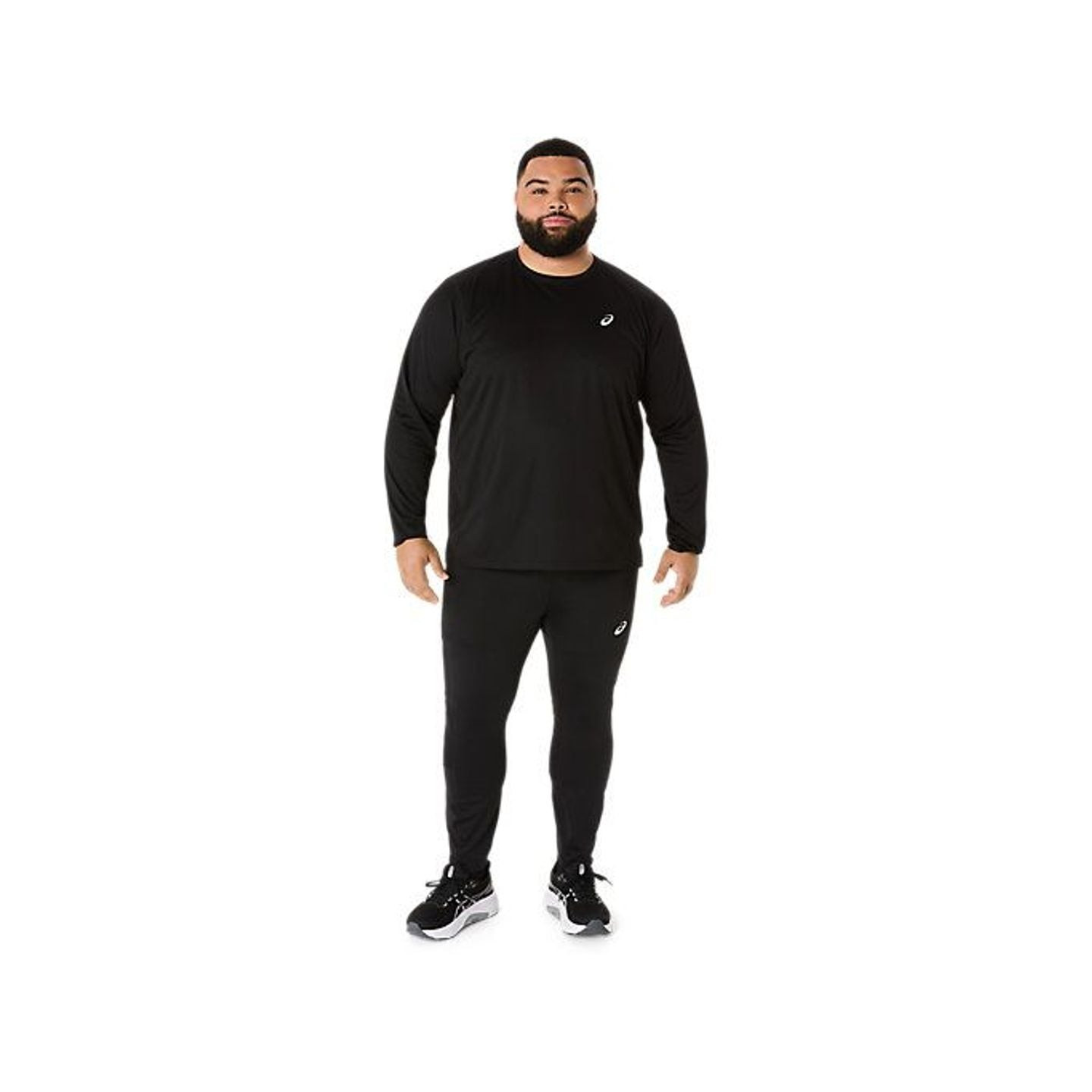 Homme portant le collant de running ASICS Core Tight noir avec un haut à manches longues assorti et 