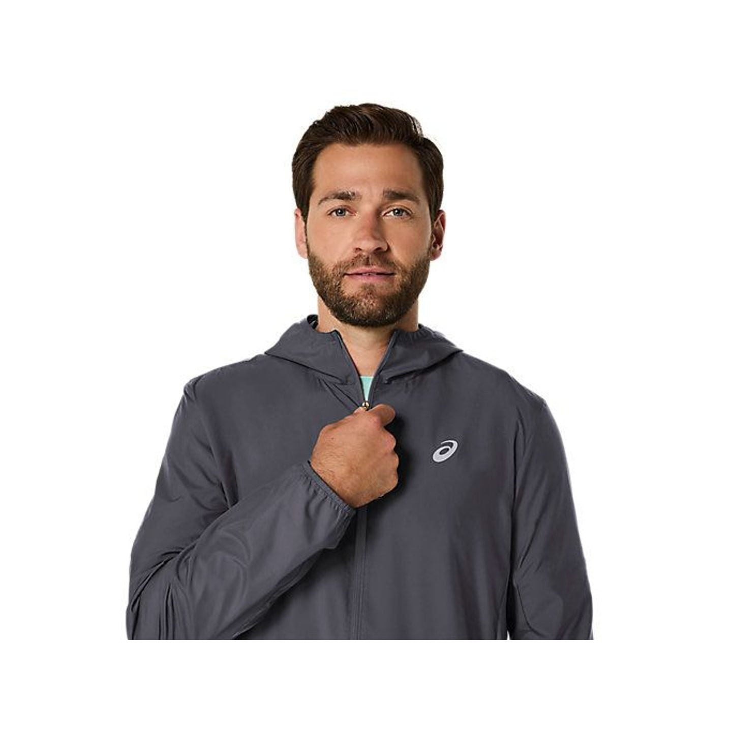 Un coureur porte la Asics Veste De Running À Capuche Core Coupe-Vent Déperlante Homme en ville.