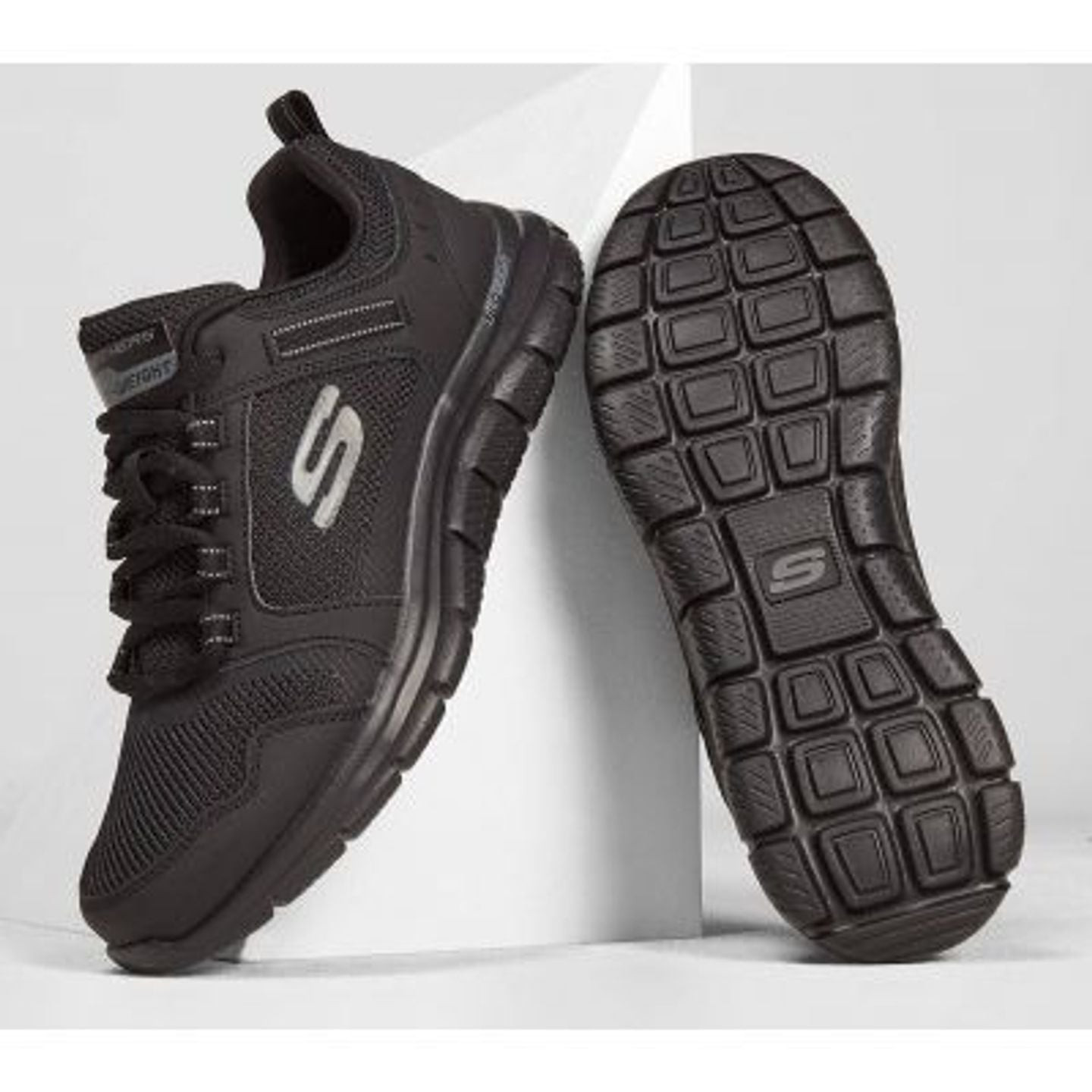 Baskets Skechers Track Knockhill noires présentées debout sur supports blancs, vues de profil et sem
